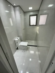 Banheiro de apartamento reformado com porcelanato de grande formato e box de vidro em São Paulo - Siolam Engenharia
