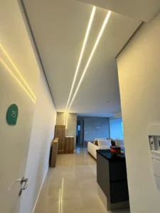 Corredor de apartamento reformado com iluminação LED linear embutida no forro de gesso - Siolam Engenharia