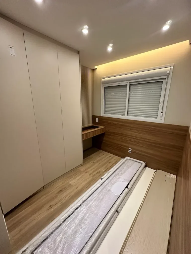 Quarto de apartamento reformado com armário planejado, painel ripado e iluminação indireta - Siolam Engenharia